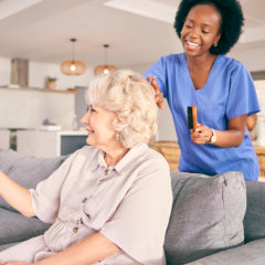 Caregiver combing elderly woman's hair