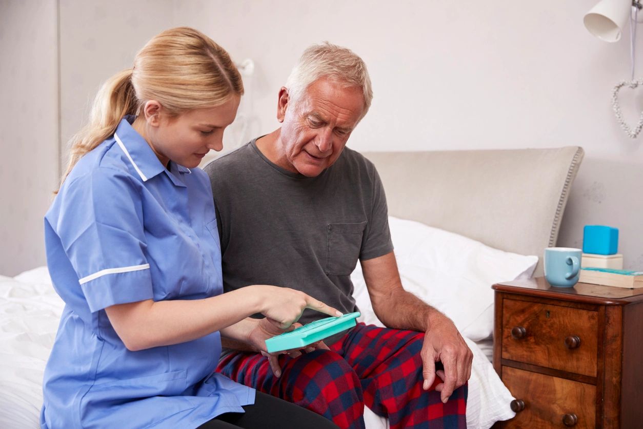 Nurse Helping Senior Man To Organize Medication On Home Visit